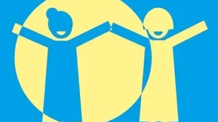 Zwei Kinder halten sich an den Händen vor einem großen gelben Kreis