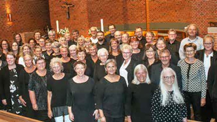 En stor gruppe af mennesker samlet i kirke.