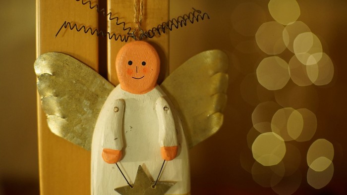 En lille engel med guldvinger og en stjerne på brystet.