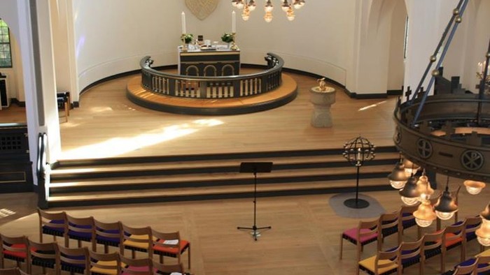 Indre del af kirke med alter, orgel og stoler