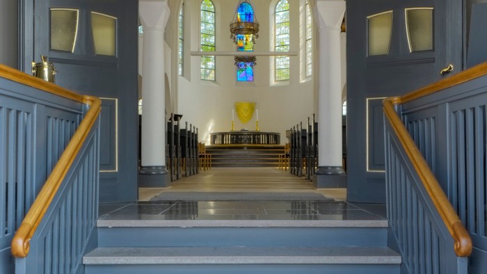 Blå trappeopgang til kirke med glasmalerier
