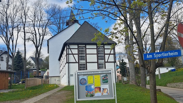 Weißes Fachwerkhaus mit Schildern an der Straße