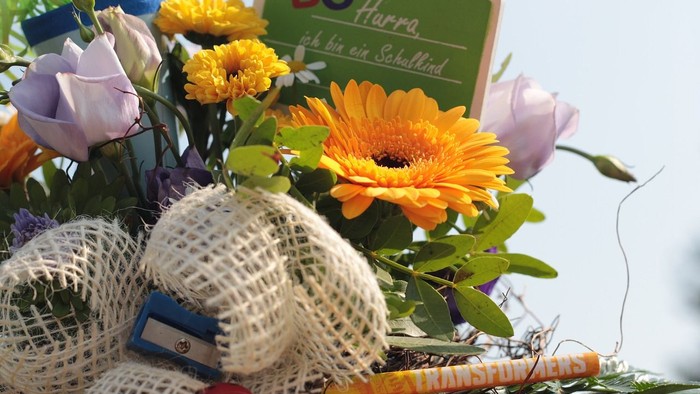 Ein Blumenstrauß mit einer Schleife und einem Schild, auf dem 