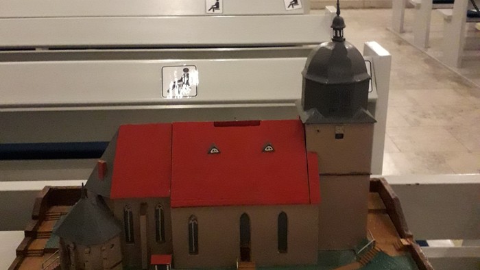 Eine Miniatur-Kirchenausstellung mit einem Glockenturm und kleinen Gebäuden.