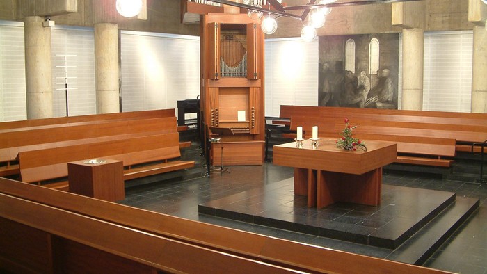 Die Kirche mit Holzgestühl und Altar im Vordergrund