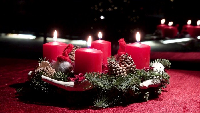 Weihnachtsdekoration mit vier brennenden Kerzen und Tannenzweigen