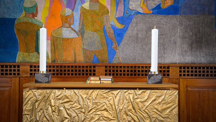 Billedet viser alter med to lysstaker og farverig vegnmålning.