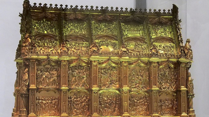 Prächtiger, goldener Altar mit detaillierten Reliefs und Inschriften in einer Kirche
