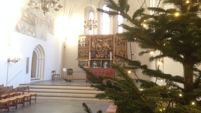 Indre del af kirke med juletree og alter.