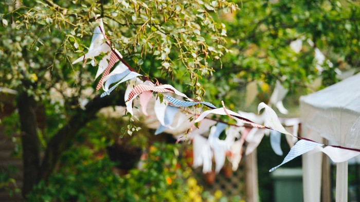 Bunte Flaggen hängen an einem Baum im Garten