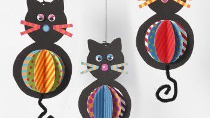 Farverige papirkat-mobiler med cirkelformede haler og legesyge øjne.