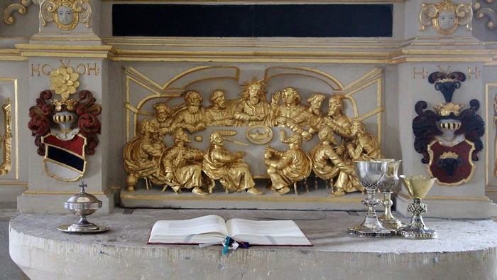 Goldene religiöse Skulptur mit Bibel und Kelchen