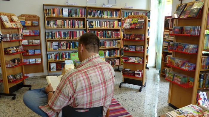Mann liest in gemütlicher Buchhandlung