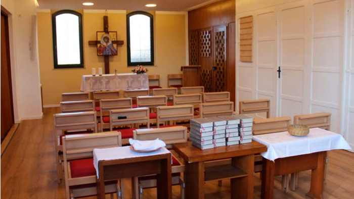 Kleine Kirche mit Holzbänken und Bücherstapel