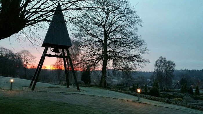 En træpyramide og træer ved skumringsbelysning i en park ved solnedgang