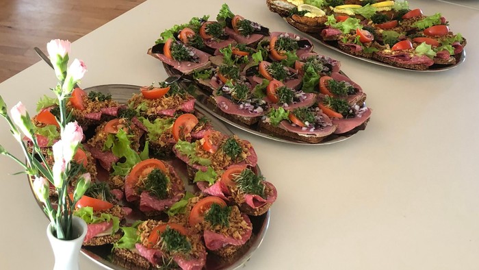 En lang bord med flere pizzer på, og stoler i baggrunden