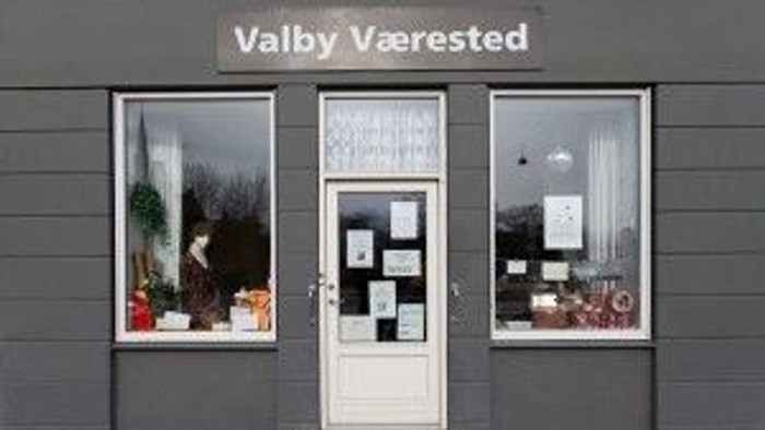  butik med hvide dører og vinduer med udstillinger