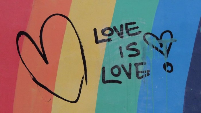 Bunter Hintergrund mit Aufschrift "Love is Love" und Herzen