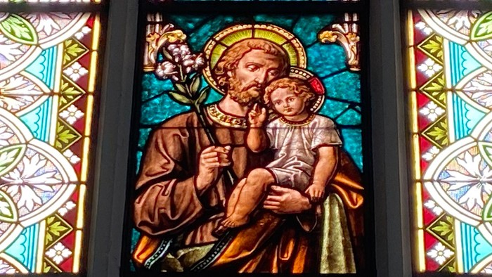 Buntes Kirchenfenster mit religiöser Darstellung