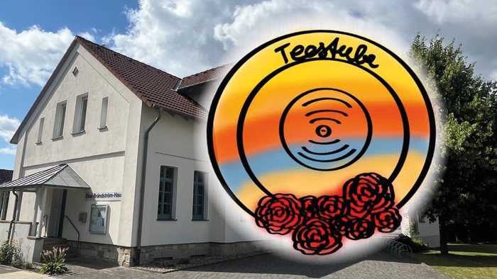 Hier sieht man das Logo der Teestube, einen gelb orangen Kreis, unten mit roten Blüten und dem Schriftzug 