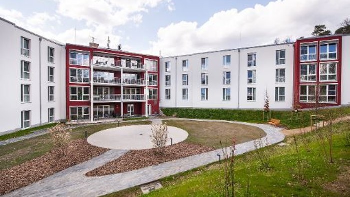 Modernes Wohnhaus mit roten Akzenten und rundem Innenhof.