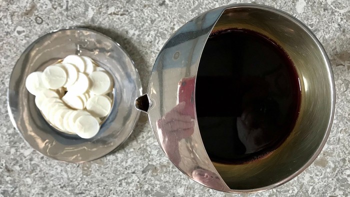 En lille bol med fløde og en stor bol med mørkt drikke.