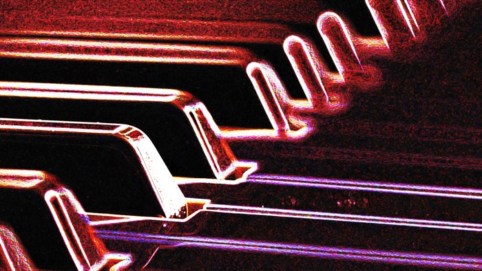 Ein Piano mit beleuchteten Tasten in Rot und Lila.
