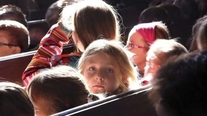 Kinder sitzen in einem Bus und schauen aus dem Fenster.