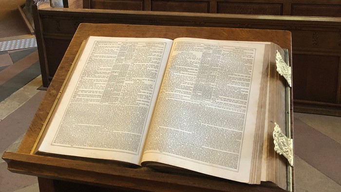 Open book on stand in church pews