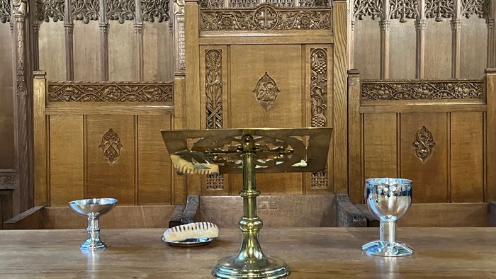 Wooden church interior with ornate paneling and brass items on table