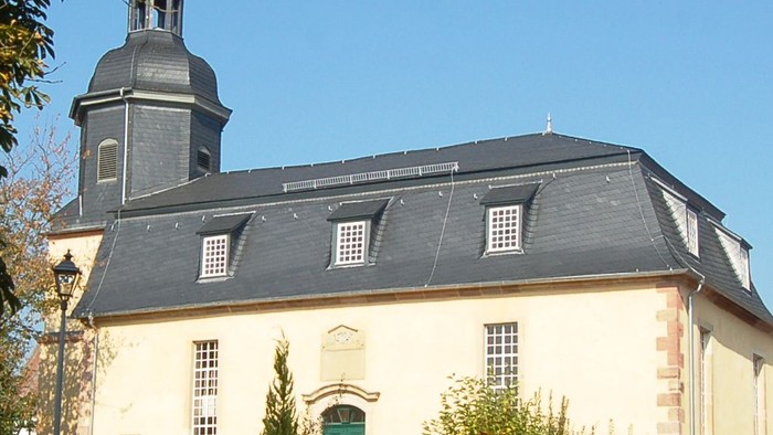 Kirche mit hohem Kirchturm und grüner Tür.