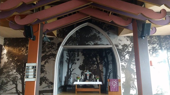 Ein traditioneller japanischer Torbogen mit Lautsprechern und einem Schrein im Hintergrund