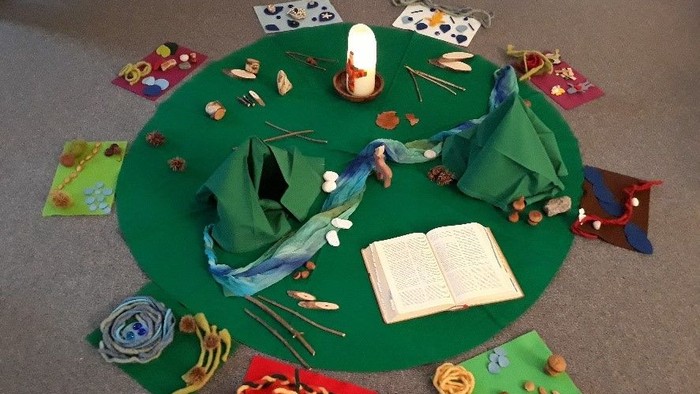 Ein grüner Tisch mit verschiedenen Bastelmaterialien und Büchern.