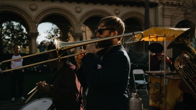 Ein Mann spielt in einer Band Trompete auf der Straße