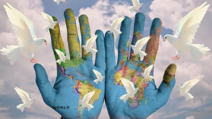 Hands holding globe with doves flying around