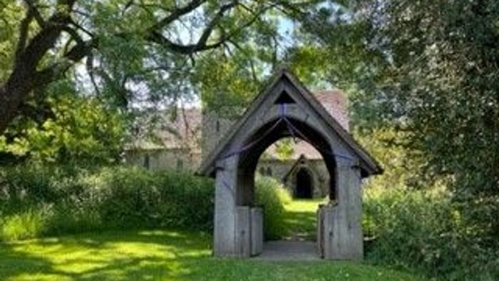 Small wooden structure in a lush green garden.