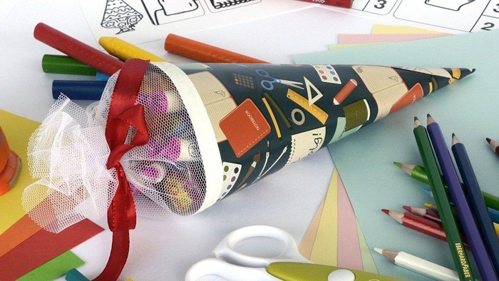 Buntstifte, Scheren und Bastelpapier auf einem Tisch