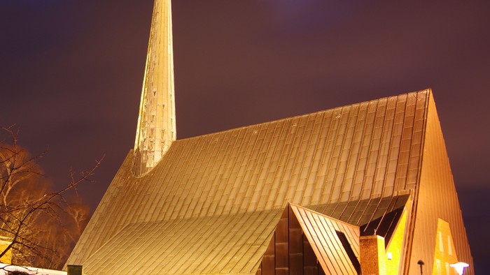 Die Kirche ist nachts beleuchtet, ein Mond ist sichtbar