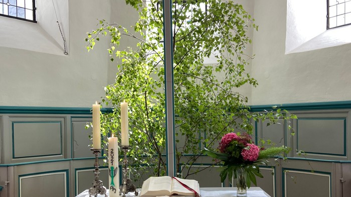 Altar in Kirche mit Blumen und Kreuz