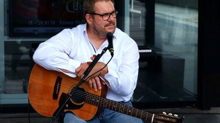 Mann spielt Gitarre auf der Straße
