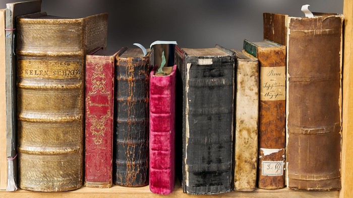 En række gamle og bragte boger på en bookshelf