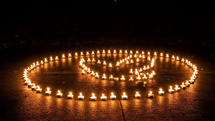 Brennende Kerzen in Form einer Friedenstaube