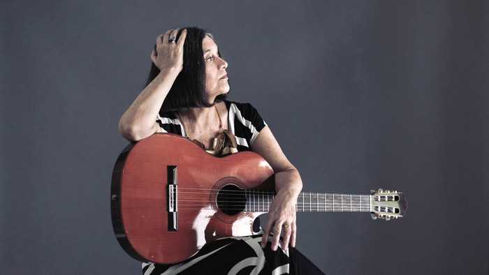 Eine Frau spielt eine rote Gitarre und singt.