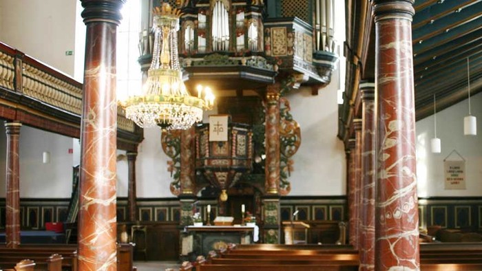 Innenraum einer Kirche mit Säulen und Kronleuchtern