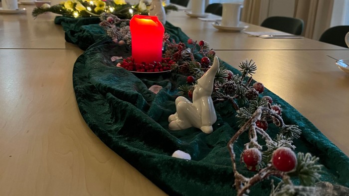 Weihnachtliche Tischdekoration mit Kerze, Hirschfigur und Tannenzweigen