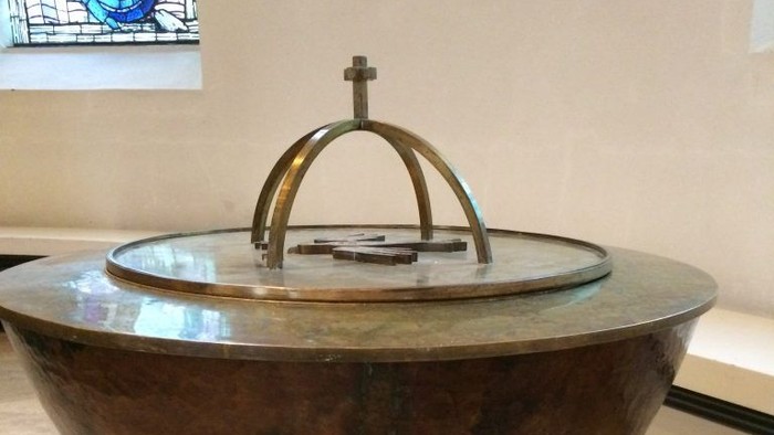 Ein großes, metallenes Weihwasserbecken in einer Kirche