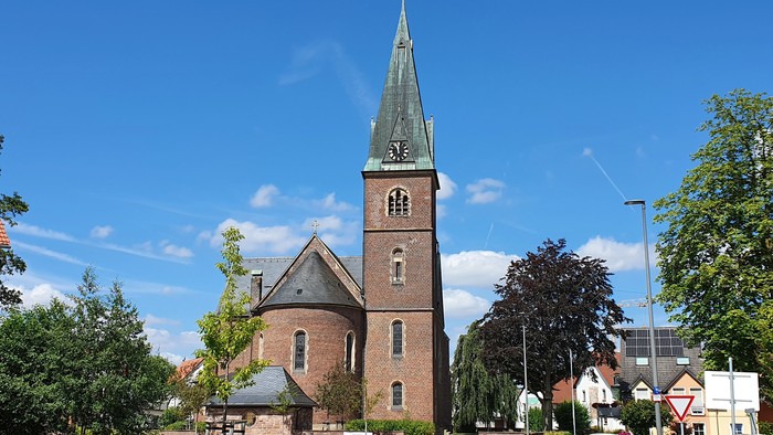 Kirchengemeinde mit hohem Turm und grünem Dach in ruhiger Umgebung