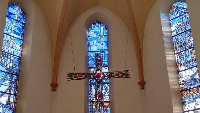 Altarkreuz und Chorfenster der Bitterfelder Herz-Jesu-Kirche.