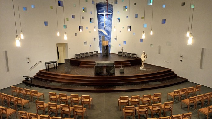 Modern Kirche mit kreisförmigem Altar und farbigen Glasfenstern