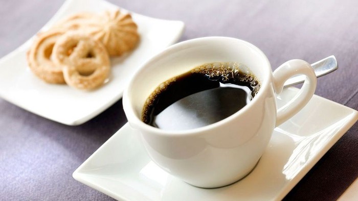 En tasse med kaffe og en plate med kager.